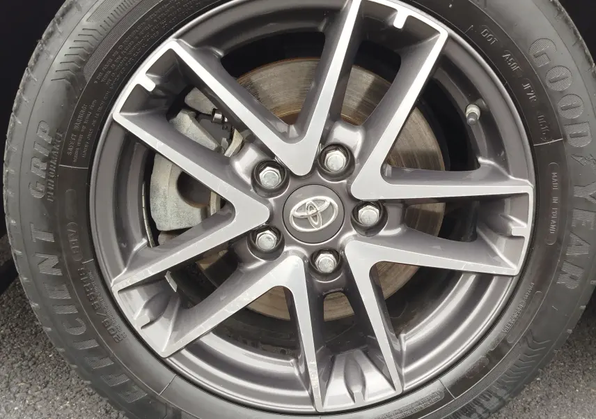 Gros plan sur la jante alliage gris foncé de la Toyota Auris HSD 136h 2015 avec logo Toyota au centre.