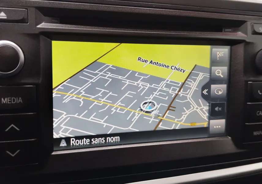 Écran de navigation GPS intégré dans une Toyota Auris HSD 136h gris aluminium, affichant une carte avec rue Antoine Chézy.