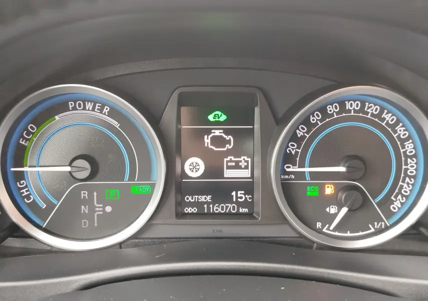 Tableau de bord de Toyota Auris HSD 136h gris, affichant 116070 km, mode ECO et température extérieure à 15°C.