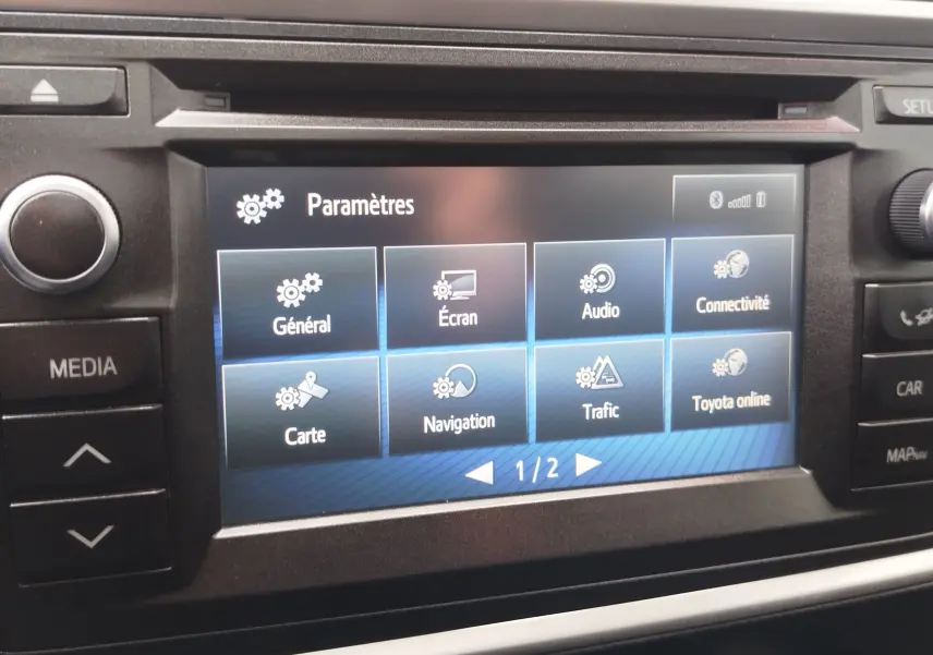 Écran tactile central de la Toyota Auris HSD 136h 2015 affichant le menu des paramètres en intérieur noir.