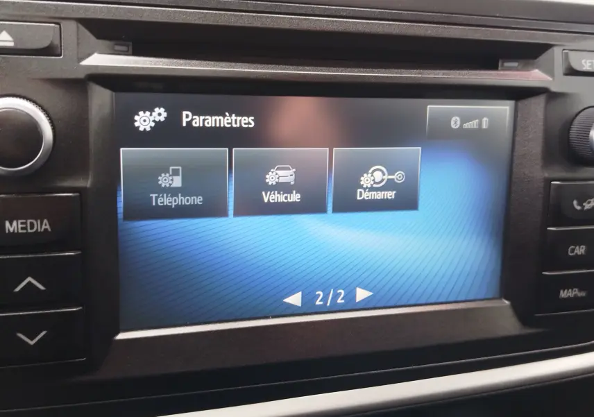 Écran central tactile de la Toyota Auris HSD 136h 2015 affichant le menu Paramètres avec options Téléphone, Véhicule et Démarrer.