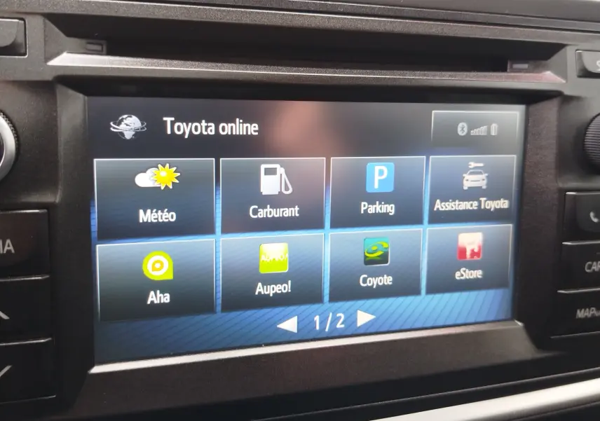 Écran tactile central de la Toyota Auris HSD 136h 2015 affichant les options Toyota online en intérieur.