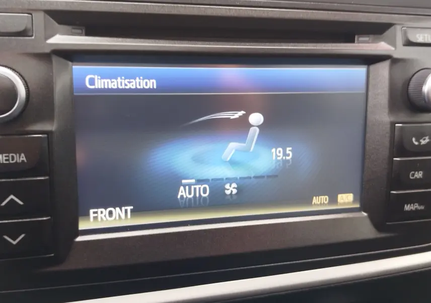 Écran central de la Toyota Auris HSD 136h gris aluminium montrant le réglage automatique de la climatisation à 19,5°C.