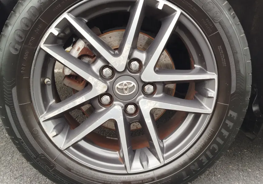 Gros plan sur la jante alliage gris foncé avec logo Toyota au centre, pneu Goodyear Efficient Grip visible.