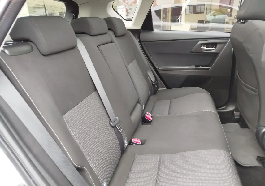 Vue intérieure côté droit des sièges arrière gris foncé de la Toyota Auris HSD 136h 2015, avec ceintures de sécurité visibles.