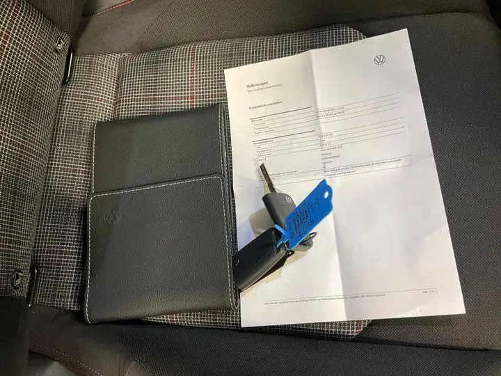 Vue intérieure du siège conducteur tissu à motif écossais de la Volkswagen Polo GTI 2024 avec clé et document posé dessus.