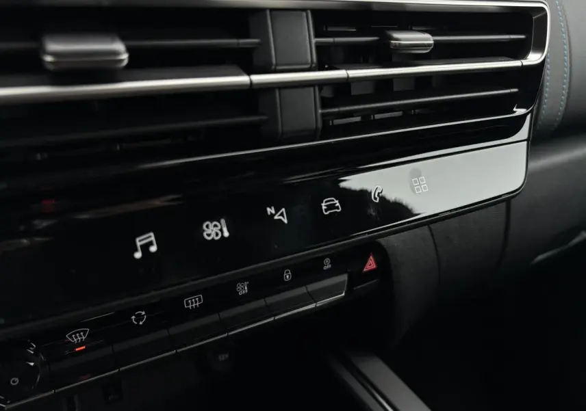 Détail de la console centrale noire brillante avec commandes tactiles et aérateurs horizontaux du Citroën C5 Aircross 2025.