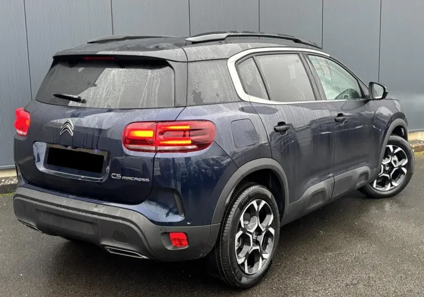 Vue 3/4 arrière droite d'un Citroën C5 Aircross Bleu Eclipse avec feux arrière LED et jantes alliage bi-ton.