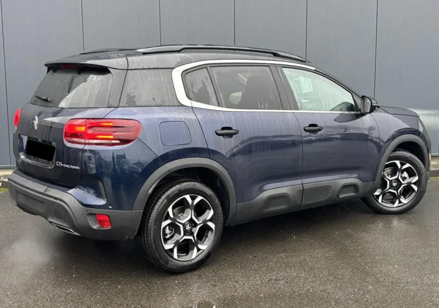 Vue 3/4 arrière droite du Citroën C5 Aircross bleu Eclipse avec jantes alliage bi-ton et toit noir.