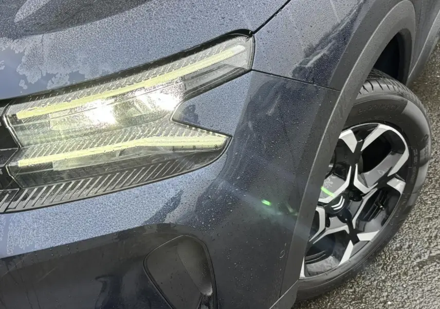 Gros plan sur l'avant droit bleu Eclipse du Citroën C5 Aircross 2025, mettant en valeur le phare LED et la jante alliage 18'' bi-ton.