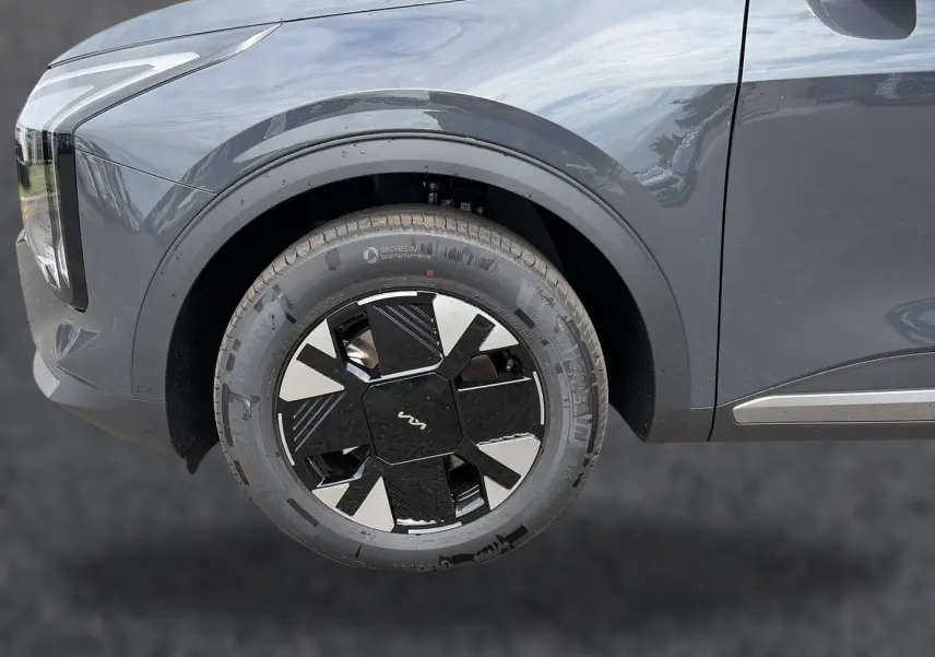 Gros plan sur la roue avant gauche du KIA Sportage gris eclipse, mettant en valeur la jante alu 17 pouces au design moderne.