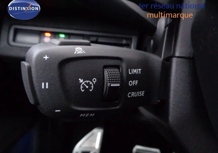 Gros plan sur la commande de régulateur de vitesse du Peugeot 3008 gris Artense 2023, avec molette et symboles blancs.