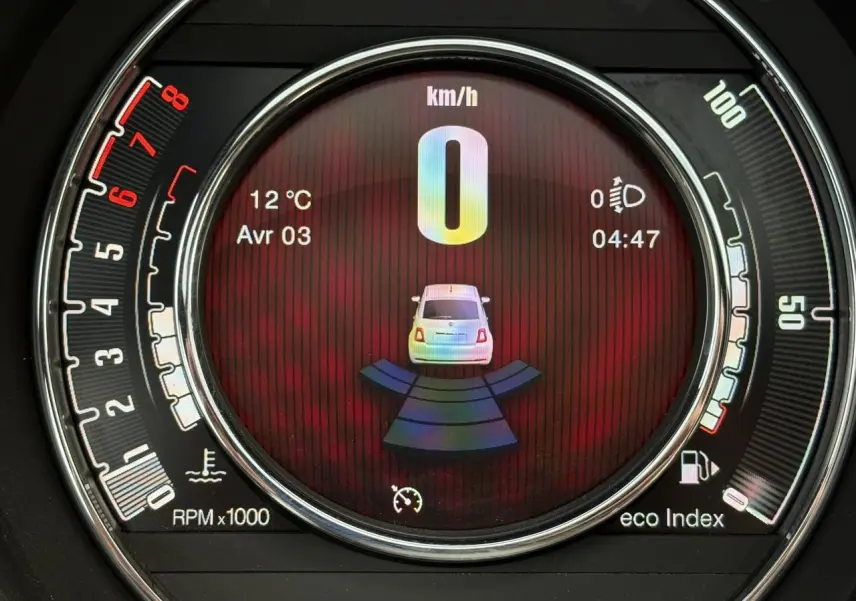 Affichage numérique central du combiné de bord de la Fiat 500 Hybrid 2024, montrant la vitesse à 0 km/h et le radar de recul actif.