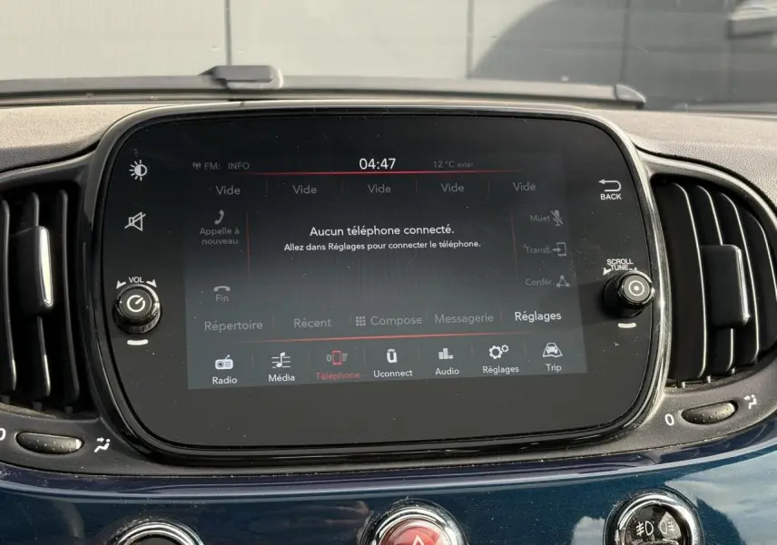 Gros plan sur l’écran tactile central du tableau de bord d’une FIAT 500 Hybrid bleu Dipinto, affichage multimédia.