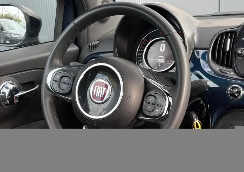 Vue intérieure centrée sur le volant noir et le tableau de bord bleu Dipinto de la Fiat 500 Hybrid 2024.