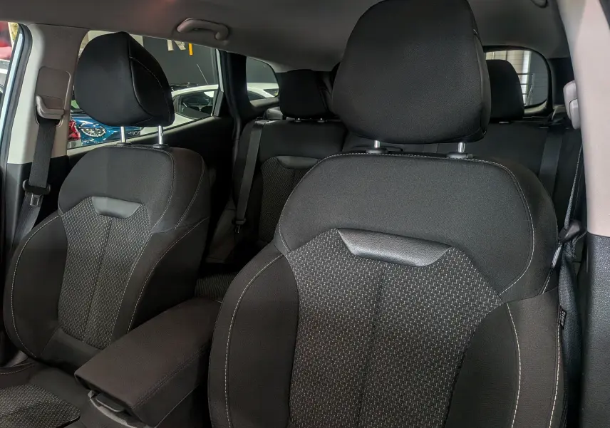 Vue intérieure rapprochée des sièges avant noirs en tissu du Renault Kadjar 2021, avec appuie-têtes et ceintures visibles.