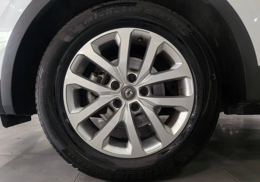 Gros plan sur la roue avant droite du Renault Kadjar blanc glacier, avec jante alliage et logo Renault central.