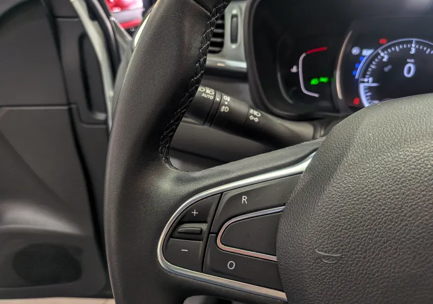 Gros plan sur le volant noir et les commandes intégrées du Renault Kadjar 2021, tableau de bord partiellement visible en arrière-plan.