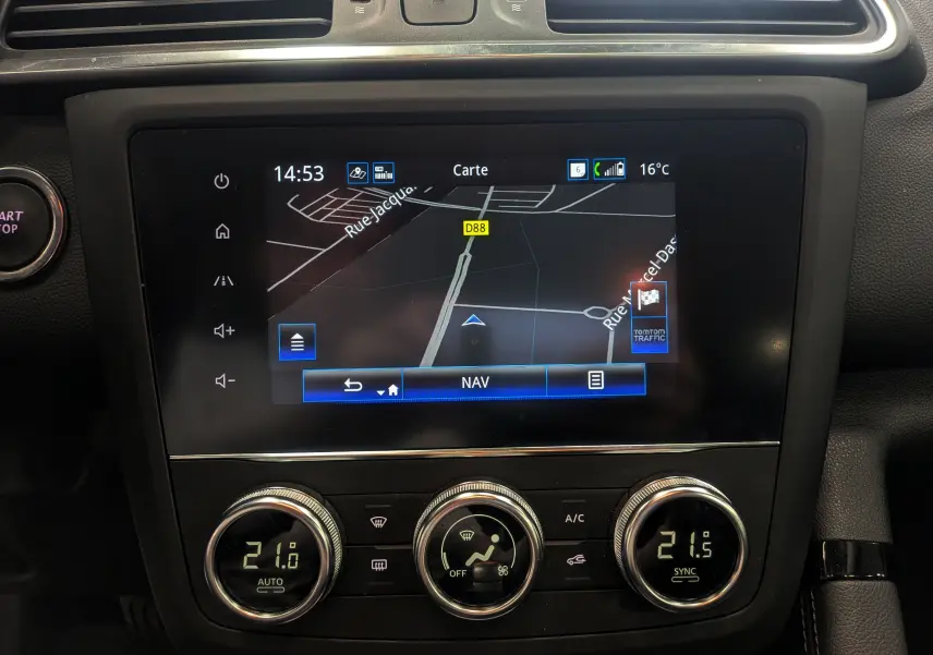 Vue rapprochée de l’écran tactile central avec navigation et commandes de climatisation du Renault Kadjar blanc Glacier 2021.