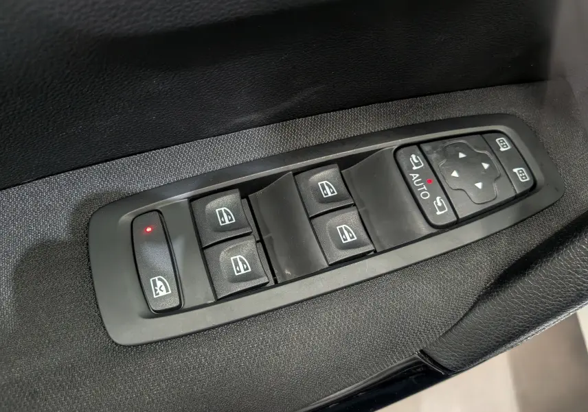 Panneau de commandes des vitres et rétroviseurs électriques sur la porte côté gauche d’un Renault Kadjar blanc Glacier.