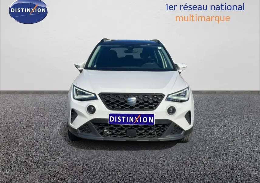 Vue frontale d'un SEAT Arona blanc avec toit gris, calandre noire et feux LED distinctifs, 2025.