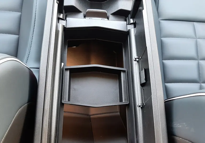 Vue plongeante sur le rangement central ouvert du Citroën C5 Aircross 2026, intérieur cuir noir avec compartiments modulables.