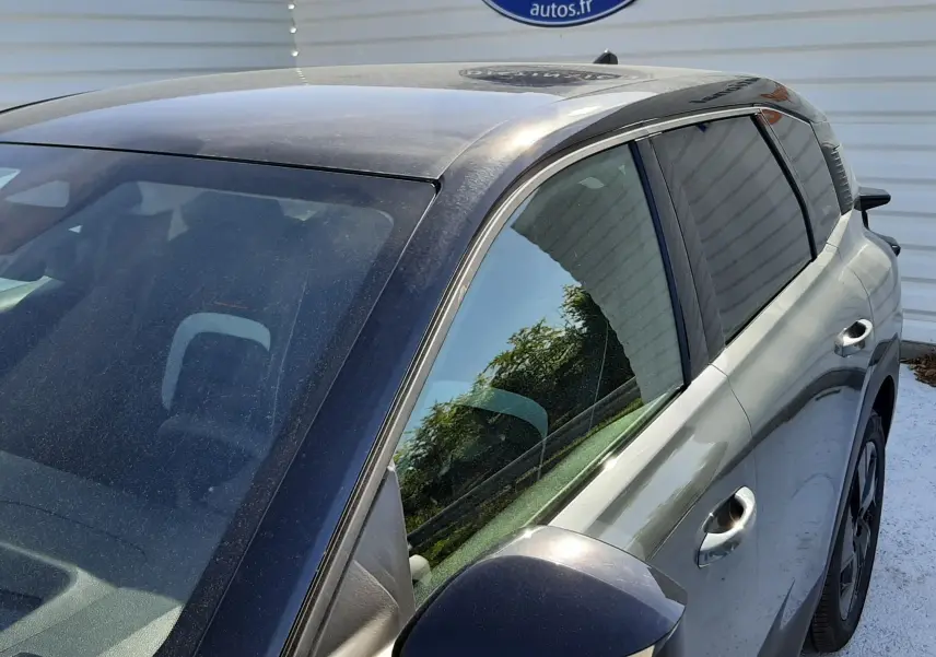 Vue côté droit en 3/4 arrière d'un Citroën C5 Aircross vert Astoria avec toit noir et rétroviseur assorti.
