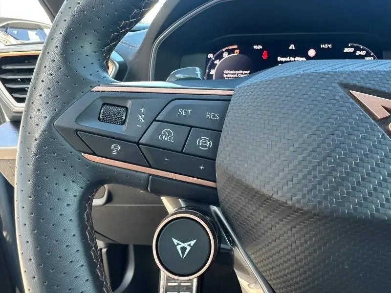 Gros plan sur le volant cuir perforé côté gauche du CUPRA Formentor bleu avec commandes multifonctions et logo central.