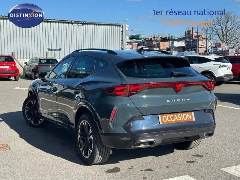 Vue 3/4 arrière droite d'une CUPRA Formentor bleu foncé avec feux arrière LED et double sortie d'échappement.