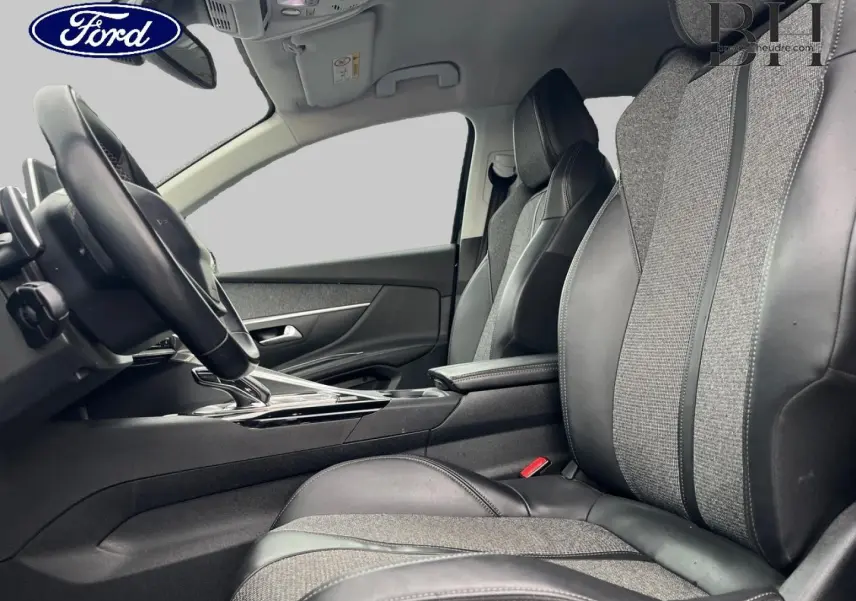 Vue intérieure côté conducteur du Peugeot 5008 2018, sièges tissu et cuir gris avec console centrale noire.