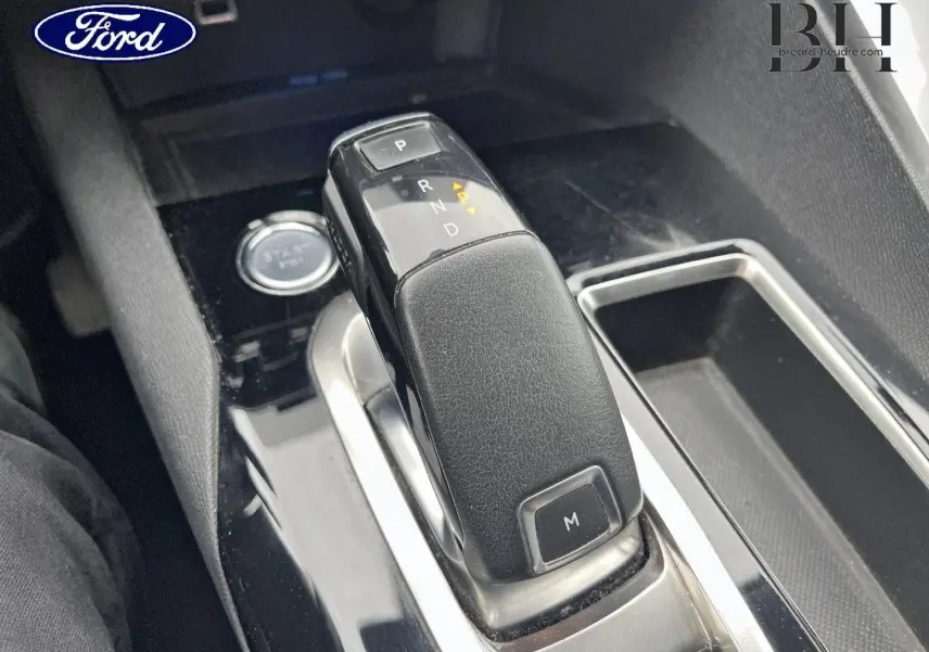 Gros plan sur la commande de boîte automatique noire dans l'habitacle d'un Peugeot 5008 noir Perla Nera.