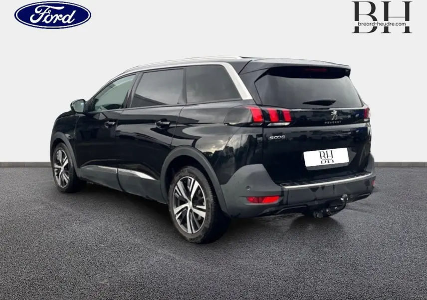 Peugeot 5008 noir Perla Nera vue 3/4 arrière gauche, avec barres de toit et jantes alliage visibles.