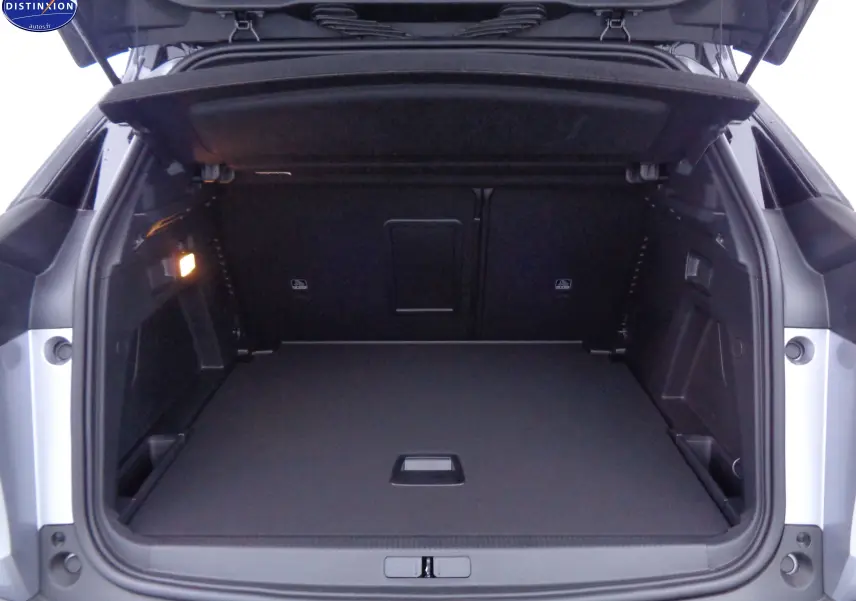Coffre ouvert d'un Peugeot 3008 gris Artense Metal, montrant un espace de chargement propre et bien éclairé.