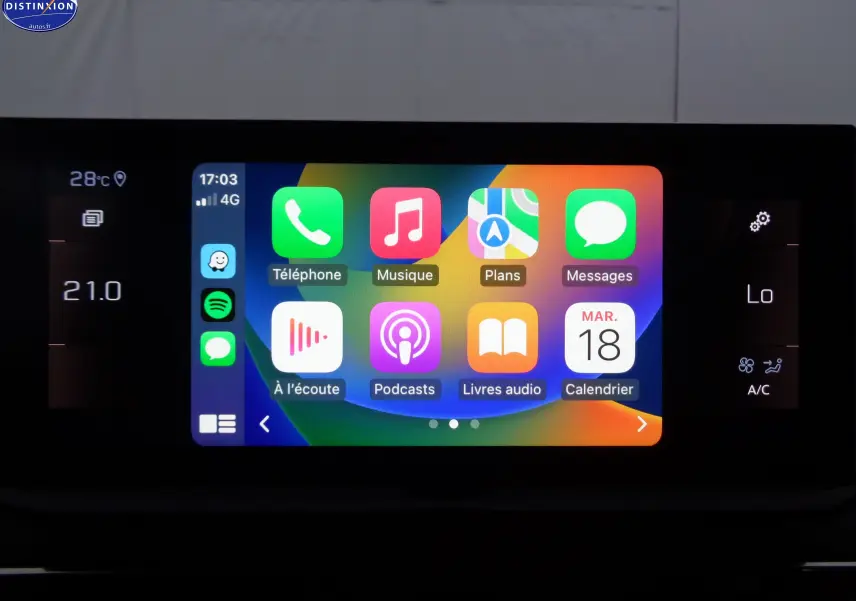 Écran tactile central du Peugeot 3008 2023 affichant les applications Apple CarPlay avec commandes climatisation visibles sur les côtés.