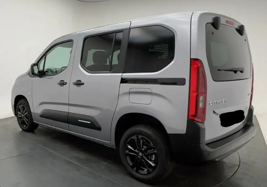 Vue 3/4 arrière droite du Citroën Berlingo Multispace gris Artense avec vitres teintées et jantes noires.