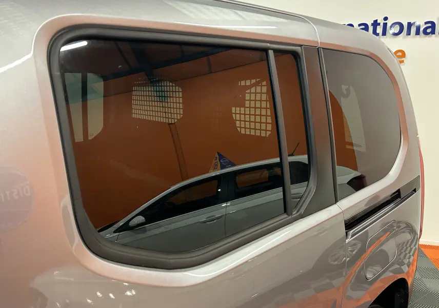 Vue latérale gauche sur la partie arrière grise Artense du Citroën Berlingo Multispace avec vitre teintée et porte coulissante.