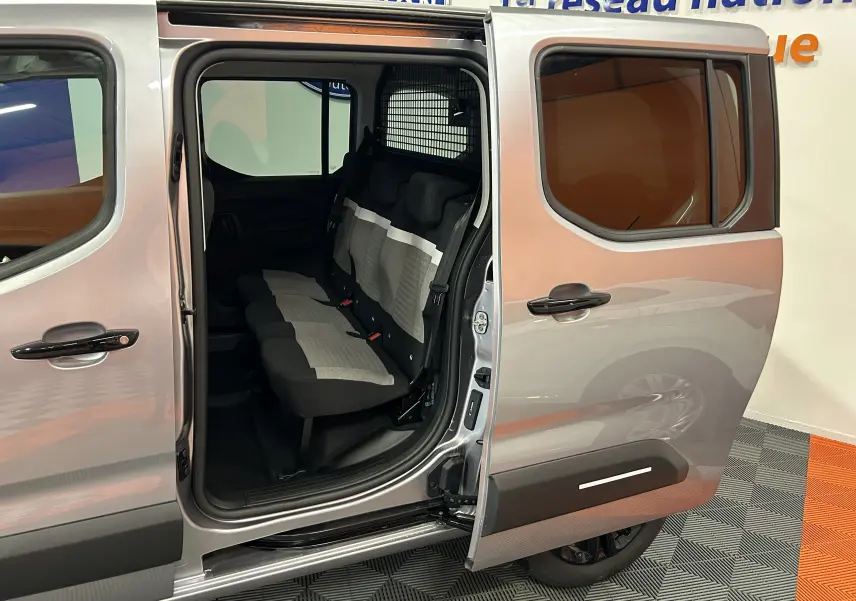 Vue latérale droite du Citroën Berlingo Multispace gris Artense avec porte coulissante ouverte révélant les sièges arrière en tissu bicolore.