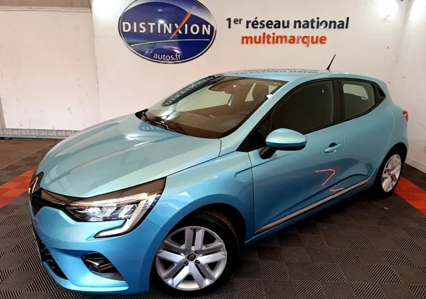 Renault Clio Business E-Tech hybride bleu vue 3/4 avant droit en intérieur avec jantes alliage et phares LED allumés.
