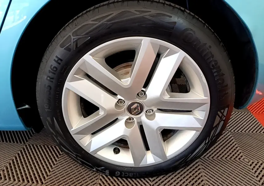 Gros plan sur la roue avant droite bleu clair d'une Renault Clio Business E-Tech hybride 2021 avec jante alliage argent.