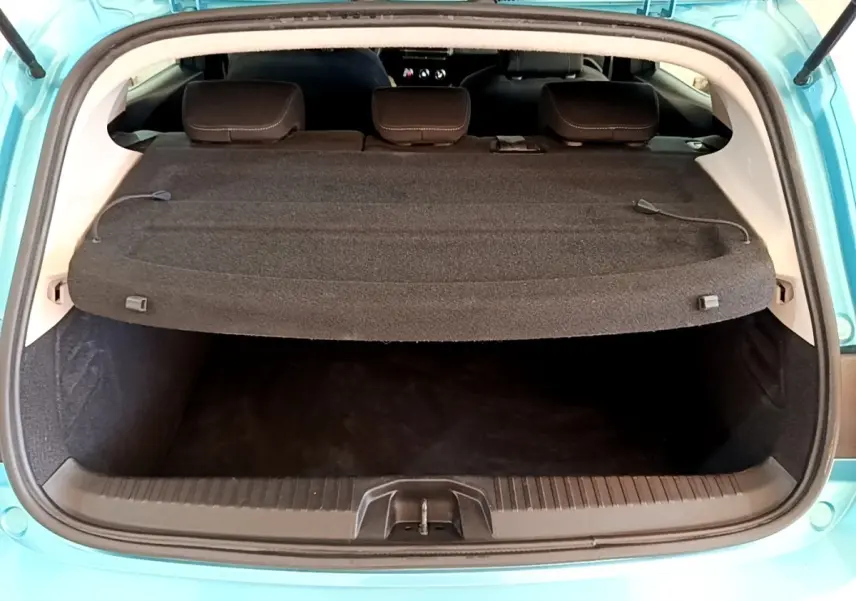 Coffre ouvert vu de l'arrière d'une Renault Clio Business E-Tech hybride bleu, avec tablette cache-bagages en place.