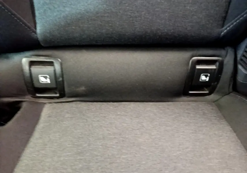 Détail des commandes de rabattement des sièges arrière en tissu gris dans une Renault Clio Business E-Tech hybride 2021.