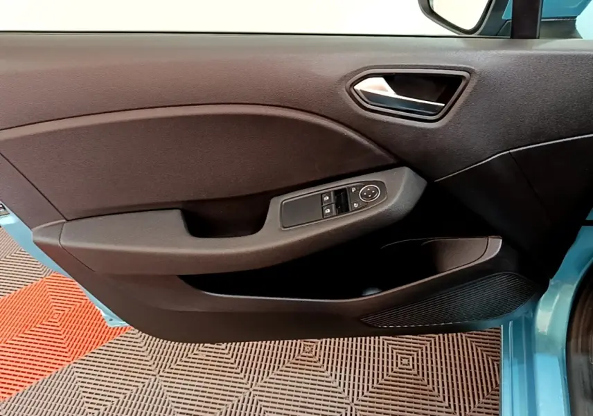 Vue intérieure du panneau de porte avant gauche d'une Renault Clio bleu, avec commandes électriques des vitres et rétroviseurs.