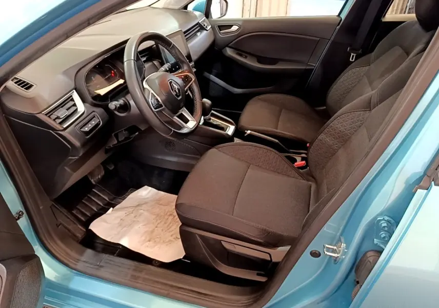 Vue intérieure côté conducteur de la Renault Clio Business E-Tech hybride bleu, avec sièges noirs et volant multifonctions.