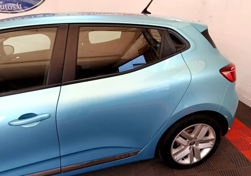 Vue latérale droite d'une Renault Clio Business E-Tech hybride 2021 bleu clair avec jantes alliage et logo Clio sur la porte arrière.