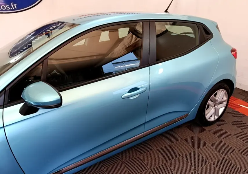Profil droit d'une Renault Clio Business E-Tech hybride 140 bleu clair, avec jantes alliage et poignées de porte intégrées.