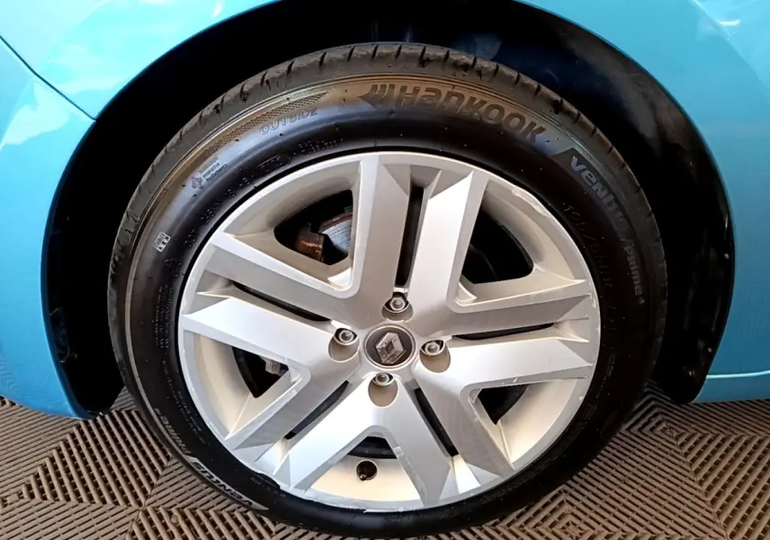 Gros plan sur la roue arrière droite d'une Renault Clio Business E-Tech hybride bleu, avec jante et pneu Hankook visibles.