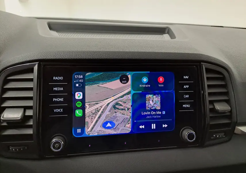 Écran tactile central du tableau de bord du Skoda Karoq 2025, affichant navigation et musique, entouré de commandes noires.