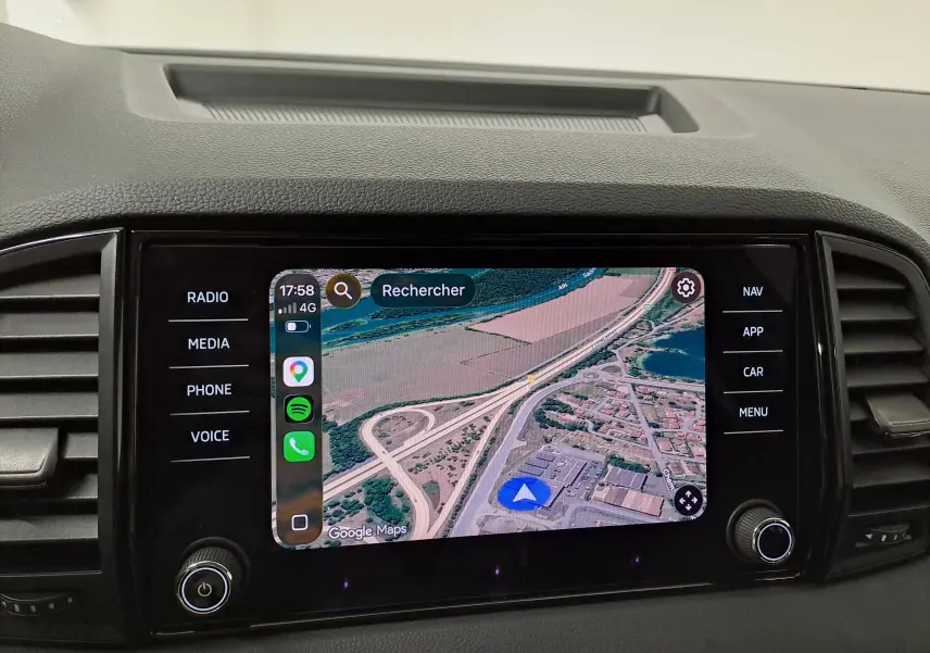 Écran tactile central du Skoda Karoq 2025 affichant la navigation GPS avec commandes autour, intérieur noir.