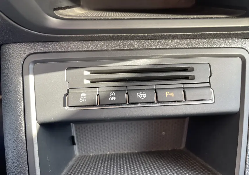 Vue rapprochée des boutons de commande du tableau de bord intérieur du Volkswagen Tiguan gris foncé 2015.