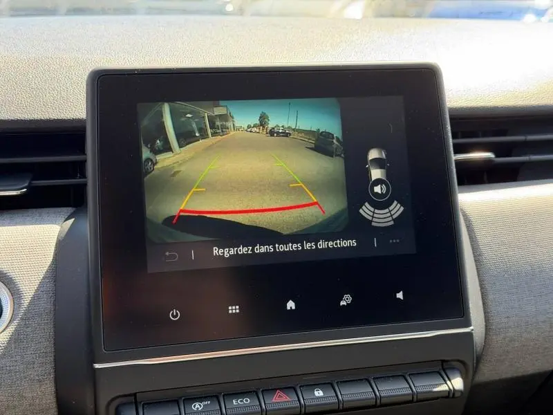 Écran tactile central de la Renault Clio 1.5 dCi 2025 affichant la caméra de recul avec lignes de guidage colorées.